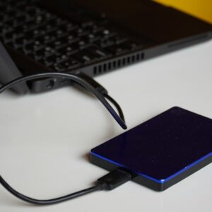 External hard drive connected to a laptop, showcasing portable storage solution.