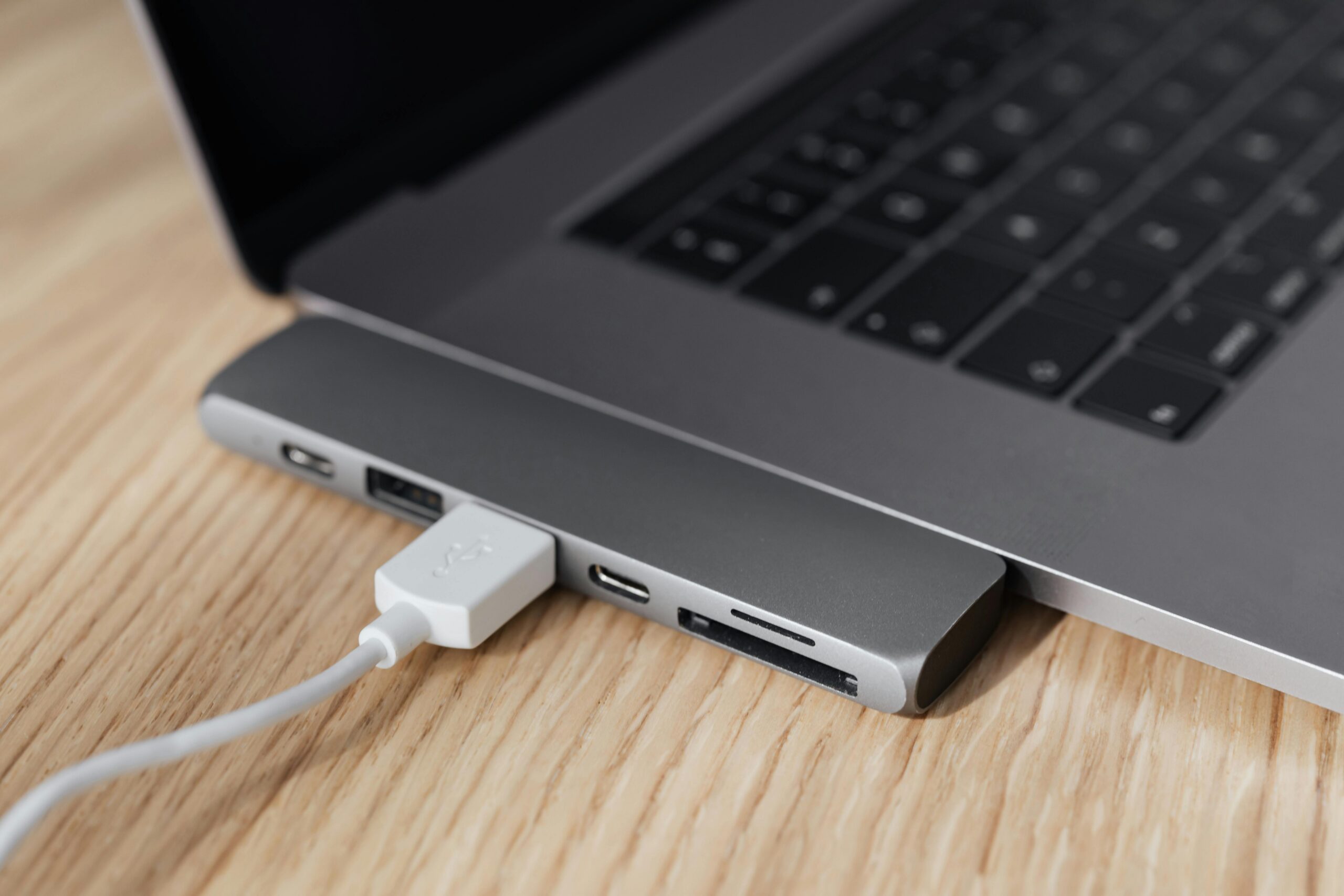 pexels photo 4195408 4195408 High angle of modern space silver laptop with USB type c multiport hub with plugged white cable placed on wooden table
