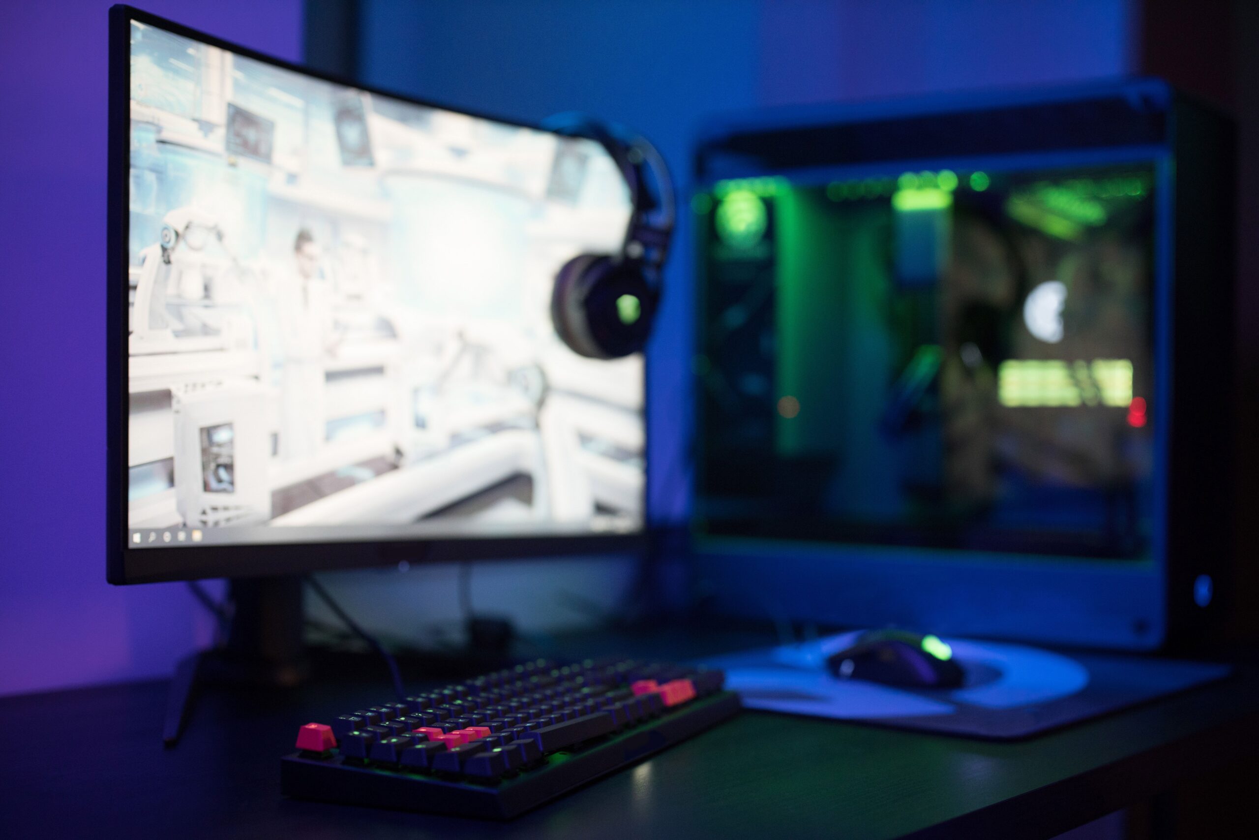 pexels photo 7858742 7858742 High-tech gaming setup featuring a curved monitor, RGB keyboard, and vibrant lighting.